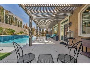 Relaxing covered patio with modern furniture and a beautiful view of the sparkling pool at 9781 Arcadian Estate Ct, Las Vegas, NV 89141