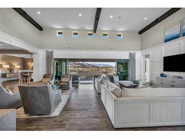 Open-concept living room boasts modern decor, wood floors, and panoramic views of the surrounding landscape at 10096 Amethyst Hills St, Las Vegas, NV 89148