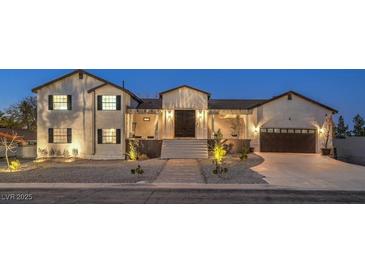 Beautiful two-story home with a well-lit front yard and modern farmhouse design at dusk at 210 E Longacres Dr, Henderson, NV 89015