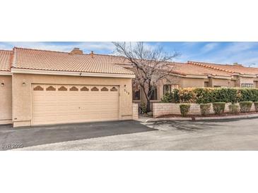 Charming single-story house featuring a two-car garage, desert landscaping, and tile roof at 213 N Cimarron Rd, Las Vegas, NV 89145