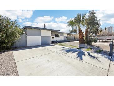 Charming single-story home boasts a checkered exterior paint design with a concrete driveway and desert landscaping at 2205 Santa Clara Dr, Las Vegas, NV 89104