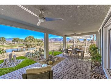 Covered patio boasts brick pavers, ceiling fans, views of the golf course, and rock and cactus landscape at 4924 E Cactus Canyon Dr, Pahrump, NV 89061
