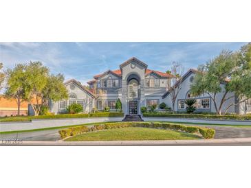 Stunning two-story home with a beautifully landscaped front yard and a symmetrical, elegant facade at 8625 Scarsdale Dr, Las Vegas, NV 89117