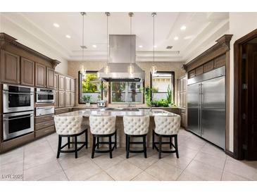 A gourmet kitchen featuring stainless steel appliances, a large island, and pendant lighting at 9325 Canyon Classic Dr, Las Vegas, NV 89144