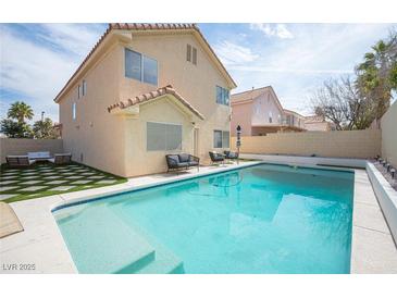 Inviting backyard pool area with lounge seating and well-maintained landscaping, perfect for outdoor relaxation at 1653 Sun Canyon Ct, Las Vegas, NV 89128