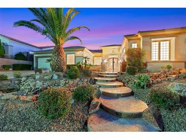Inviting front entrance with stone walkway, mature landscaping, and a glimpse of the home's architectural details at 2062 Dipinto Ave, Henderson, NV 89052