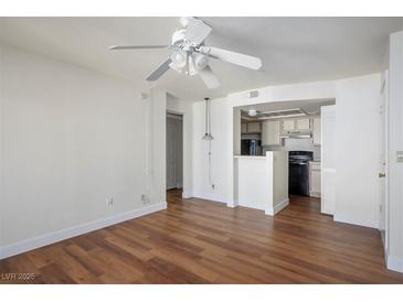 Inviting living room with wood floors and a ceiling fan, flowing into a compact kitchen area at 3550 Bay Sands Dr # 2027, Laughlin, NV 89029