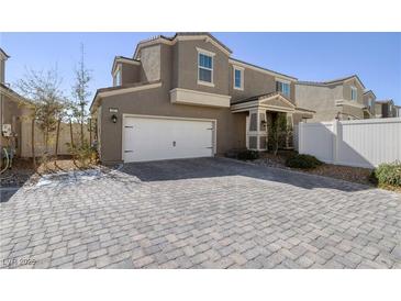 Charming home featuring a two-car garage and an inviting gray brick driveway at 357 Stone Fly Rd, North Las Vegas, NV 89032