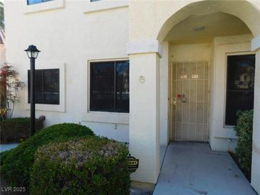 Inviting entryway featuring an arched alcove and a secure, decorative gate at 4855 S Torrey Pines Dr # 102, Las Vegas, NV 89103
