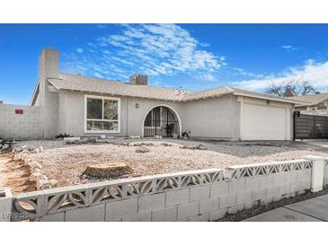 Charming single-story home featuring a stucco exterior, arched entrance, and low-maintenance gravel landscaping at 4303 E Viking Rd, Las Vegas, NV 89121