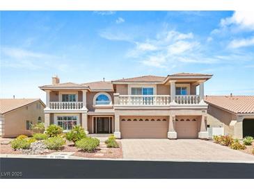 Elegant two-story home boasts dual balconies, a three-car garage, and manicured landscaping at 4542 Grey Spencer Dr, Las Vegas, NV 89141