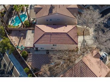 An aerial view shows the home with a pool, desert landscaping, and a brick-paved patio at 5516 Ness Ave, Las Vegas, NV 89118