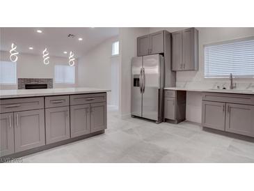 Modern kitchen featuring stainless steel appliances, grey cabinets, and stylish pendant lighting at 613 W Victory Rd, Henderson, NV 89015