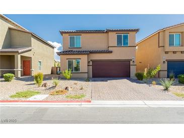 Inviting two-story home featuring a well-maintained front yard with desert landscaping and a two-car garage at 7322 Glimmer Point St, North Las Vegas, NV 89084