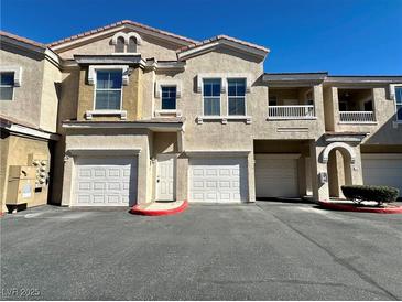 Charming multi-level townhome features well-maintained stucco facade and attached garages at 10001 Peace Way # 2353, Las Vegas, NV 89147