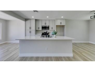 Well-lit kitchen featuring an oversized island, modern cabinets, and stainless steel microwave at 2004 Burnham Ave, Las Vegas, NV 89104