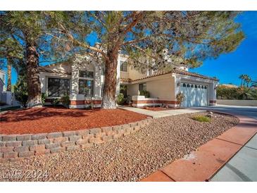 Charming two-story home featuring a well-manicured front yard with mature trees at 2638 Douglas Cir, Henderson, NV 89074