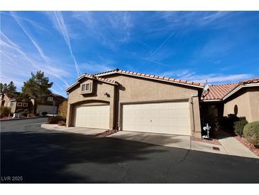 Two car garage with desert landscaping and tile roof on a sunny day at 379 Rosado Springs St, Henderson, NV 89014