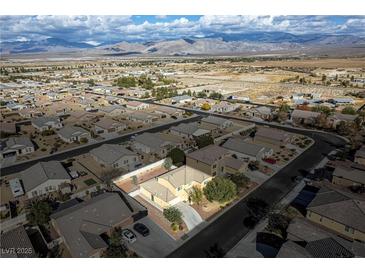 Sweeping aerial view of a residential community with mountain backdrop, showcasing neighborhood layout at 3938 E Chaffe Ave, Pahrump, NV 89061