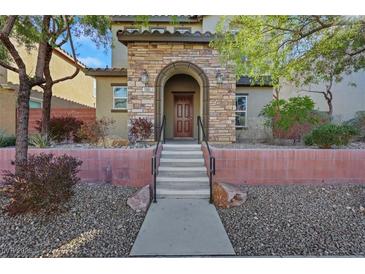 Inviting front entrance with a stone facade, tiled roof, and a well-maintained landscaped front yard at 7083 Mackenzie Bay Ave, Las Vegas, NV 89179