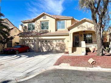 Inviting two-story home with a three car garage and a well-manicured front yard landscape at 880 Glitter Glen Ct, Las Vegas, NV 89123