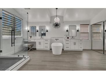 Bright bathroom featuring a modern soaking tub, double vanity, and glass enclosed shower at 2008 Arbor Forest St, Las Vegas, NV 89134