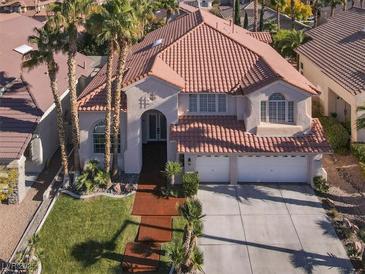 Elegant two-story home with a three-car garage, red tile roof, and palm tree landscaping at 2008 Arbor Forest St, Las Vegas, NV 89134