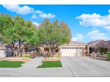 Charming single-story home featuring mature trees, a well-manicured lawn, and a spacious driveway at 2244 Garden City Ave, Henderson, NV 89052