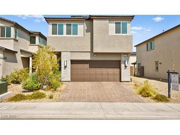 Two-story home featuring a brick driveway leading up to a two-car garage and stone accents at 2724 High Echelon Rd, North Las Vegas, NV 89086