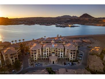 Stunning aerial view of a lakeside apartment complex with a beautiful landscape and mountain views at sunset at 30 Via Mantova # 202, Henderson, NV 89011