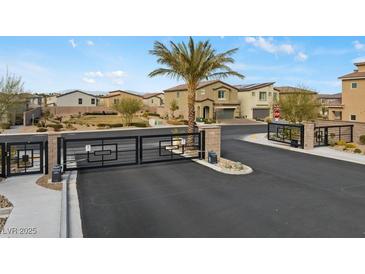 View of the community entrance gate with desert landscaping and well-maintained homes at 7462 Dragonfruit Ave, Las Vegas, NV 89113