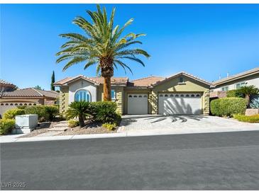 Charming single-story home featuring a lush green lawn, mature palm tree, and a two-car garage at 77 Chapman Heights St, Las Vegas, NV 89138