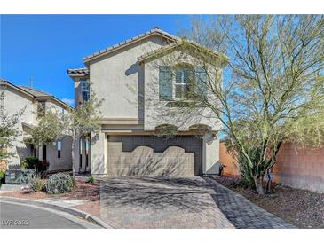 Two-story stucco home with a two-car garage and a brick driveway under a clear blue sky at 7870 Formitch Ct, Las Vegas, NV 89166