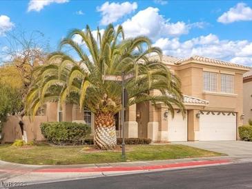 Attractive two-story home featuring a lush front yard and a spacious three-car garage at 8970 Lansberry Ct, Las Vegas, NV 89147