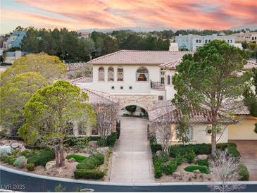 Elegant two-story home boasts lush landscaping, mature trees and a beautiful neutral palette at 9325 Verlaine Ct, Las Vegas, NV 89145