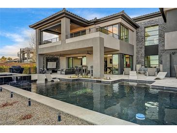 Beautiful outdoor living area with pool, spa, lounge chairs, and covered seating area at 11296 Villa Bellagio Dr, Las Vegas, NV 89141