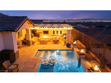 Inviting pool area with a covered patio and outdoor seating, perfect for relaxing and entertaining at 12217 Tempestad Ave, Las Vegas, NV 89138