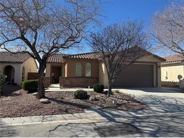 Charming single-story home featuring a tile roof, arched windows, desert landscaping, and a two-car garage at 4300 S Gressa St, Pahrump, NV 89061