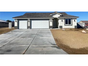 Charming single-story home featuring a three-car garage and modern architectural details at 6360 Montclair St, Pahrump, NV 89061