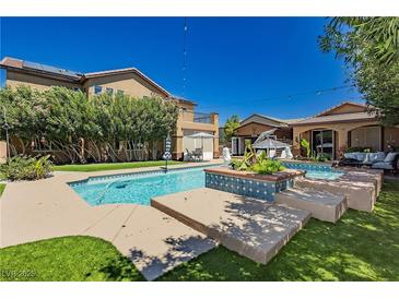Beautiful backyard pool with lounge area, lush landscaping and outdoor seating offers a relaxing oasis at 6391 Tempting Choice Ave, Las Vegas, NV 89131