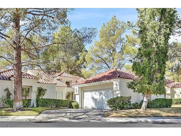 Charming single-story home with a tile roof, mature trees, and an attached two car garage at 6959 Emerald Springs Ln, Las Vegas, NV 89113