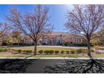 Stately residence boasts a circular driveway, mature trees, and impeccable landscaping creating an inviting curb appeal at 9631 Orient Express Ct, Las Vegas, NV 89145