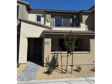 Charming two-story home featuring a balcony, neutral tones, and a well-maintained front yard with tasteful landscaping at 11443 Ethereal Landing Ave, Las Vegas, NV 89138