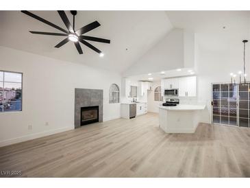 Bright living space featuring a fireplace, ceiling fan, and updated kitchen with stainless appliances at 2925 Wigwam Pkwy # 923, Henderson, NV 89074