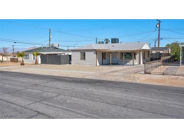 Charming single story home with gravel yard, covered porch, and convenient driveway access at 457 Federal St, Henderson, NV 89015