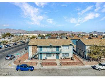 Two story apartment building featuring a balcony and yard surrounded by chain link fence at 4708 Thunderbolt Ave, Las Vegas, NV 89115