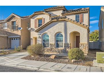 Charming two-story home with arched windows and stone accents, showcasing a cozy and inviting facade at 5958 W Agate Ave, Las Vegas, NV 89139