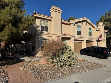 Charming two-story townhome with desert landscaping, attached garages, and well-maintained stucco exterior at 2834 Crystal Lantern Dr, Henderson, NV 89074