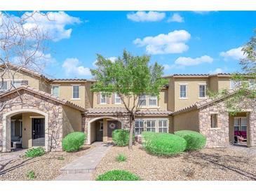 Charming townhome features a stone facade, well-manicured landscaping, and inviting walkway leading to the front door at 3064 Bicentennial Pkwy, Henderson, NV 89044