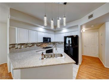 Bright kitchen features granite countertops, stainless steel appliances, and modern lighting fixtures at 312 Manti Pl, Henderson, NV 89014